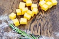 Cheese cubes on a wooden board decorated with greens. Tasting of natural, agricultural products Royalty Free Stock Photo