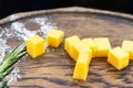 Cheese cubes on a wooden board decorated with herbs. Close-up Royalty Free Stock Photo