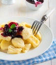 Cheese dumplings,gnocchi with sauce of black currants in a white ceramic plate for a healthy breakfast. Selective focus