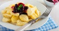 Cheese dumplings,gnocchi with sauce of black currants in a white ceramic plate for a healthy breakfast. Selective focus