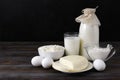 Cheese, eggs, cottage cheese, sour cream, glass and bottle of milk protein products on a dark wooden Royalty Free Stock Photo