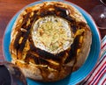 Cheese fondue from camembert in bread bowl