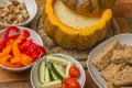 Cheese fondue in a roasted pumpkin with bread and vegetables Royalty Free Stock Photo