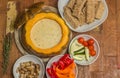 Cheese fondue in a roasted pumpkin with bread and vegetables Royalty Free Stock Photo