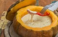 Cheese fondue in a roasted pumpkin with pepper on a fork Royalty Free Stock Photo