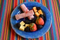 Cheese,fruit, and lean lunch meat on a vibrant plate Royalty Free Stock Photo