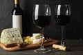 Cheese, grape, bottle and glasses with wine on wooden background Royalty Free Stock Photo
