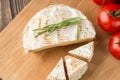 Brie cheese and tomato slice on wood cutting board. Royalty Free Stock Photo