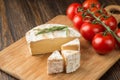 Brie cheese and tomato slice on wood cutting board. Royalty Free Stock Photo