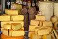 Cheese heads of different colors and sizes are stacked on counter. Fair trade in homemade cheese. Inscriptions in Romanian