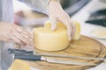 Cheese heads on market counter, seller sells cheese, cut cheese heads on wooden market board. Selective focus Royalty Free Stock Photo
