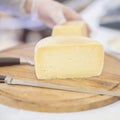 Cheese heads on market , seller sells cheese, hands of seller in gloves. Selective focus. Gastronomic dairy produce Royalty Free Stock Photo