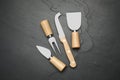 Cheese knives and fork on black stone table, flat lay