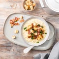 Cheese leek soup with croutons and bacon in a bowl on a wooden table Royalty Free Stock Photo