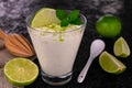 Cheese lime mint dessert in a glass on a black background.