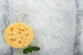 Cheese Maasdam or Radamer. Piece of cheese on black marble or stone standa on old grey concrete background. Top view. Free space f