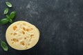 Cheese Maasdam or Radamer. Piece of cheese on black marble or stone standa on black concrete background. Top view. Free space for