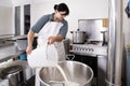 Cheese Maker pours milk into a steel container