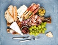 Cheese and meat appetizer selection or wine snack set. Variety of cheese, salami, prosciutto, bread sticks, baguette, honey, grap Royalty Free Stock Photo