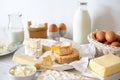 Cheese, milk, dairy products and eggs on rustic white wood background.