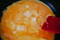 Cheese omelet cooking in pan with red silicone spatula Royalty Free Stock Photo