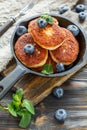 Cheese pancakes and blueberries in cast iron pan. Royalty Free Stock Photo