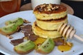 cheese pancakes, chocolate and kiwi lie on a white plate