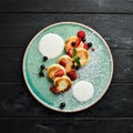 Cheese pancakes with strawberries and sour cream. Breakfast. In the plate. Top view. Flat lay composition Royalty Free Stock Photo