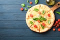 Cheese pizza, tomatoes and olive oil on wooden background