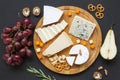 Cheese plate. Assorted cheeses with fruits, walnuts and pretzels. Food for wine. Royalty Free Stock Photo