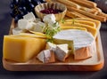 cheese plate and bread sticks on dark grey table Royalty Free Stock Photo
