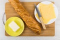 Cheese in plate, butter, knife, bread on cutting board Royalty Free Stock Photo