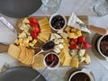 Cheese plate with camembert, brie, dor blue, strawberries, sun-dried tomatoes, olives on a wooden table, top view