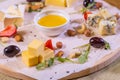 Cheese plate with cheeses Dorblu, Parmesan, Brie, Camembert and Roquefort in serving on the table from an old tree close Royalty Free Stock Photo