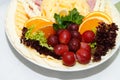 Cheese plate decorated with grapes and oranges