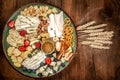 Cheese plate with different types of cheese with honey and nuts, blueberries and strawberries. Sliced pieces of various cheese on Royalty Free Stock Photo