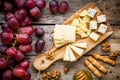 Cheese plate: Emmental, Camembert cheese, blue cheese, bread sticks, walnuts, hazelnuts, honey, grapes