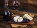 Cheese plate with grape and wine on wood Royalty Free Stock Photo