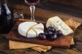 Cheese plate with grape and wine on wood Royalty Free Stock Photo
