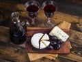 Cheese plate with grape and wine on wood Royalty Free Stock Photo