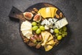 Cheese plate with grapes, figs and nuts.