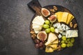 Cheese plate with grapes, figs and nuts.