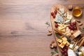 Cheese plate with honey, grapes and nuts on wooden table, flat lay. Space for text Royalty Free Stock Photo