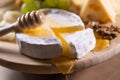 Cheese plate, honey pouring on camembert cheese Royalty Free Stock Photo