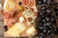 Cheese plate with pieces moldy cheese, prosciutto, pickled plum Royalty Free Stock Photo