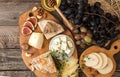 Cheese plate with pieces moldy cheese, prosciutto, pickled plums Royalty Free Stock Photo