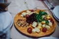 Cheese plate in a restaurant at a banquet. Table setting with appetizers. Wooden tray with sliced cheeses