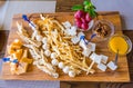 Cheese plate in the restaurant. Different varieties of cheese on a wooden tray. Honey, grapes and walnuts Royalty Free Stock Photo