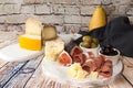 Cheese plate with Slices and blocks of cheese, prosciutto, olive Royalty Free Stock Photo