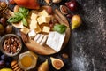 Cheese plate, still life of seasonal wine snacks. Brie cheese, fresh figs, grapes, cheese cubes, pears, pecan nuts and honey on Royalty Free Stock Photo